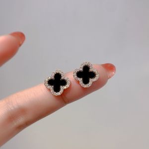 EUR290 diamante edge petal earrings in Black